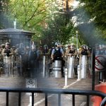 people standing near gray metal fence during daytime