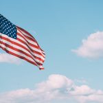 flag of U.S.A. under white clouds during daytime