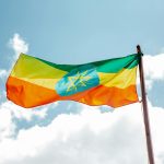 National colorful flag of Ethiopia under cloudy sky