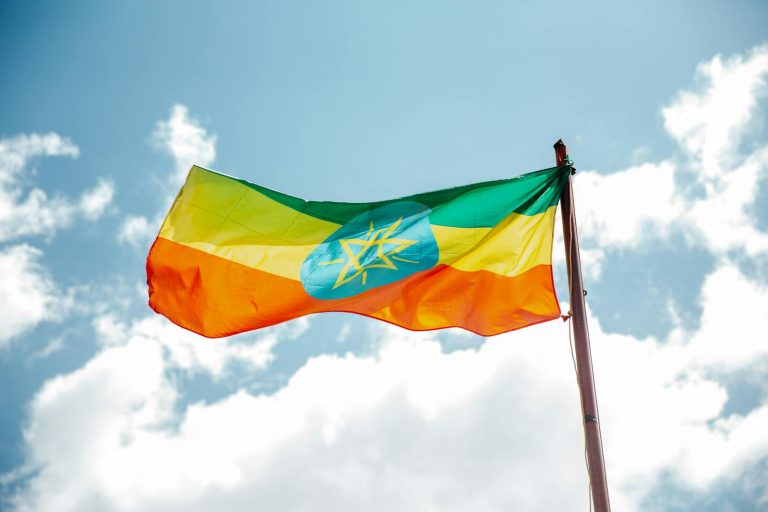 National colorful flag of Ethiopia under cloudy sky