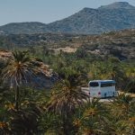 white van on green grass field near mountain during daytime