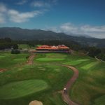 an aerial view of a golf course surrounded by mountains