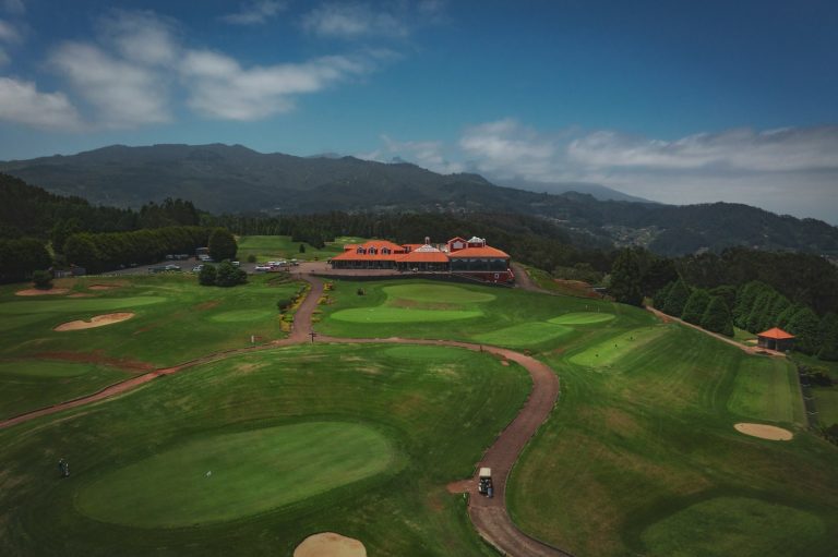 an aerial view of a golf course surrounded by mountains