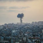 smoke billows from a factory in a city