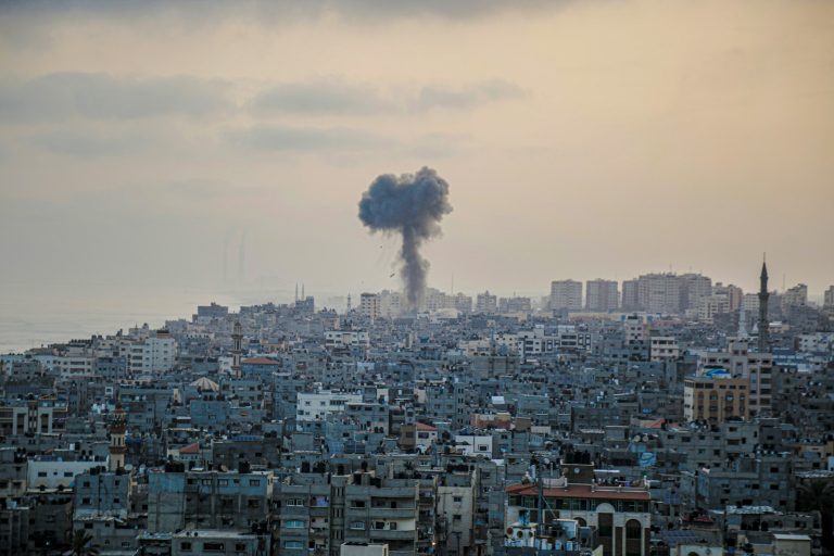 smoke billows from a factory in a city