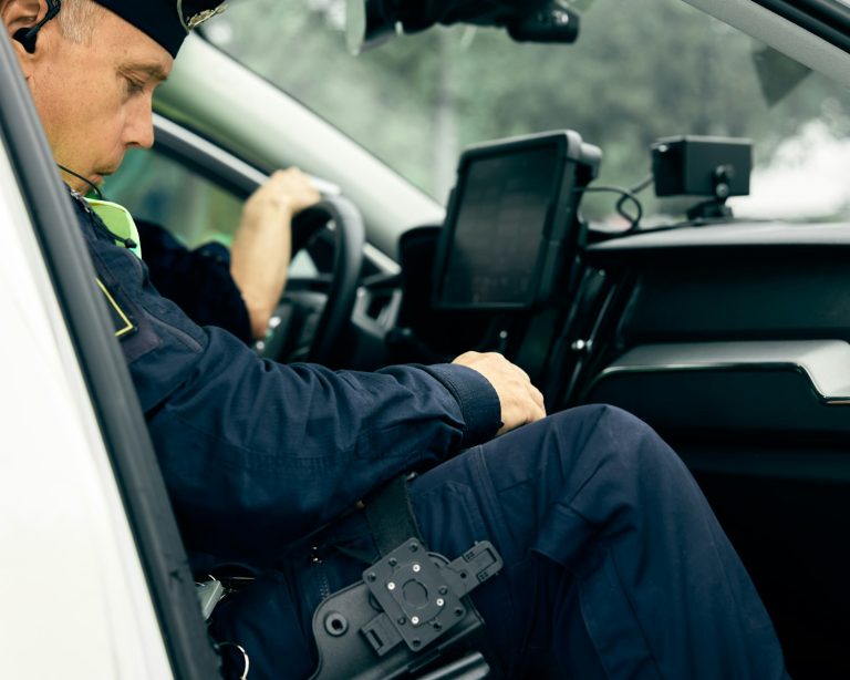 a police officer sitting in the driver's seat of a car