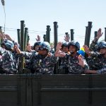 soldiers in brown and black camouflage uniform sitting on black metal frame during daytime