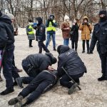 a group of people standing around a man on the ground