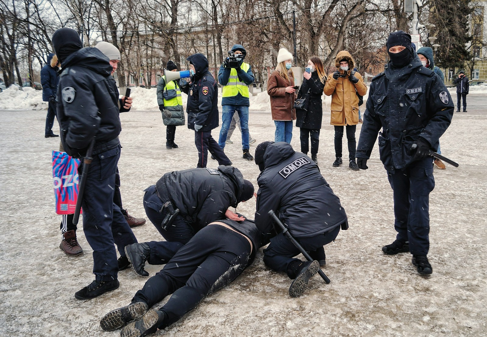 a group of people standing around a man on the ground