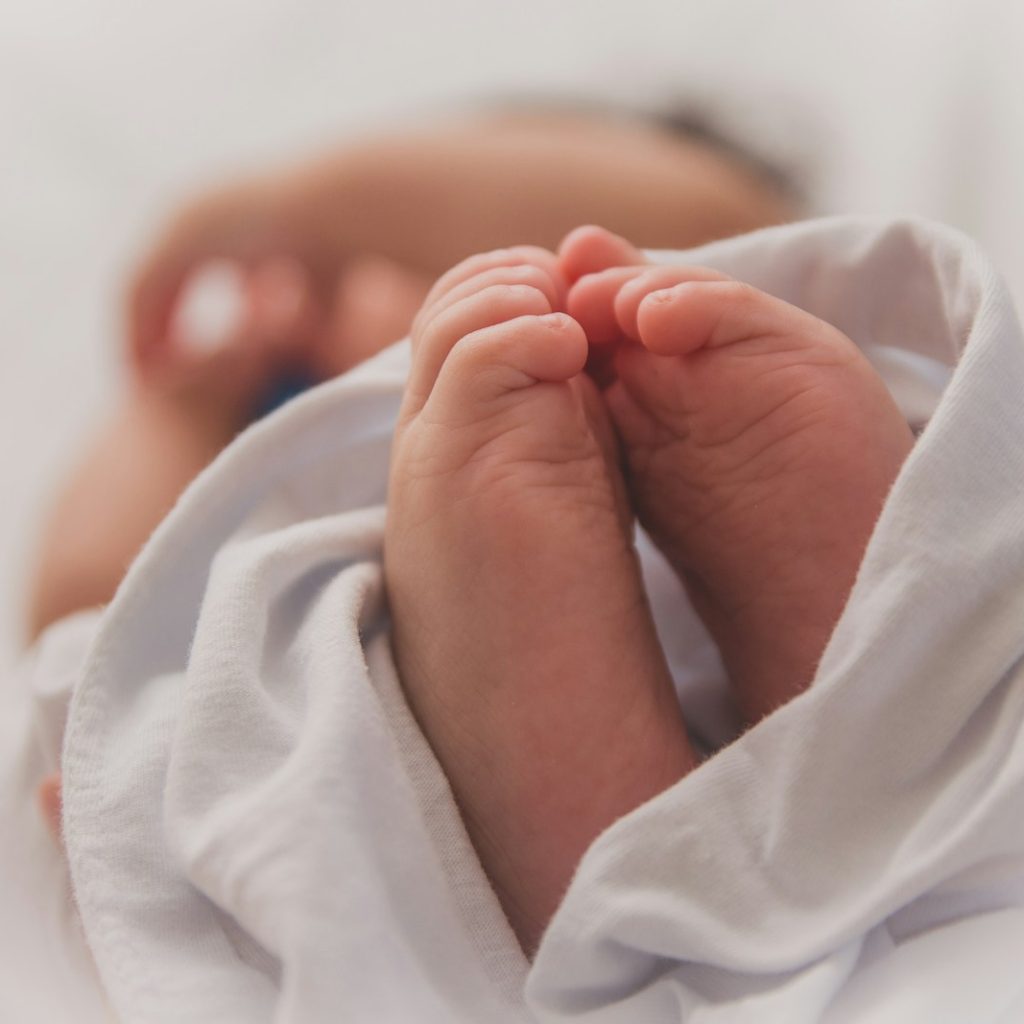 baby covered with white blanket