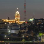 a city at night with a very tall building in the background