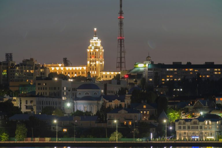 a city at night with a very tall building in the background