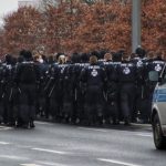 a group of police officers standing in front of a police car