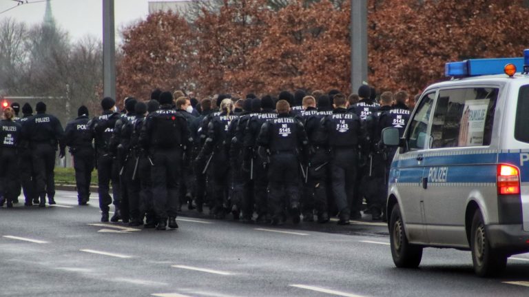 a group of police officers standing in front of a police car