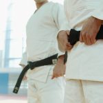 Close-Up Shot of Two People Wearing Karategi and Black Belt