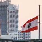 The Lebanese Flag on Pole with the Marina Tower in Beirut, Lebanon on Background