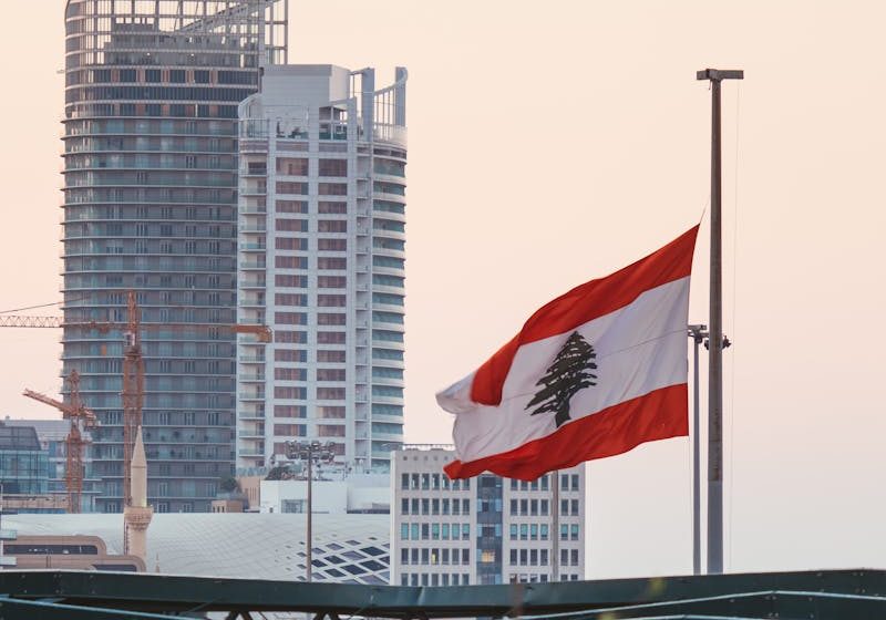 The Lebanese Flag on Pole with the Marina Tower in Beirut, Lebanon on Background