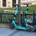 a blue scooter parked next to a black fence