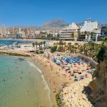 a beach with people and buildings by it