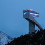 white tower near snow-capped mountain