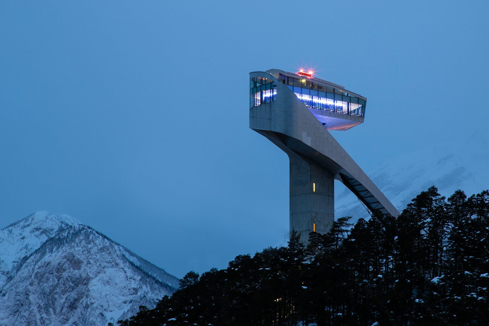 white tower near snow-capped mountain