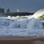 water smashing through rocks on seashore during daytime