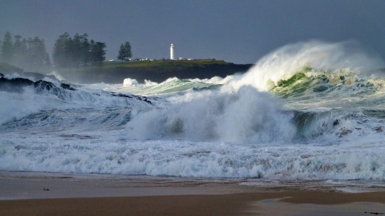 water smashing through rocks on seashore during daytime