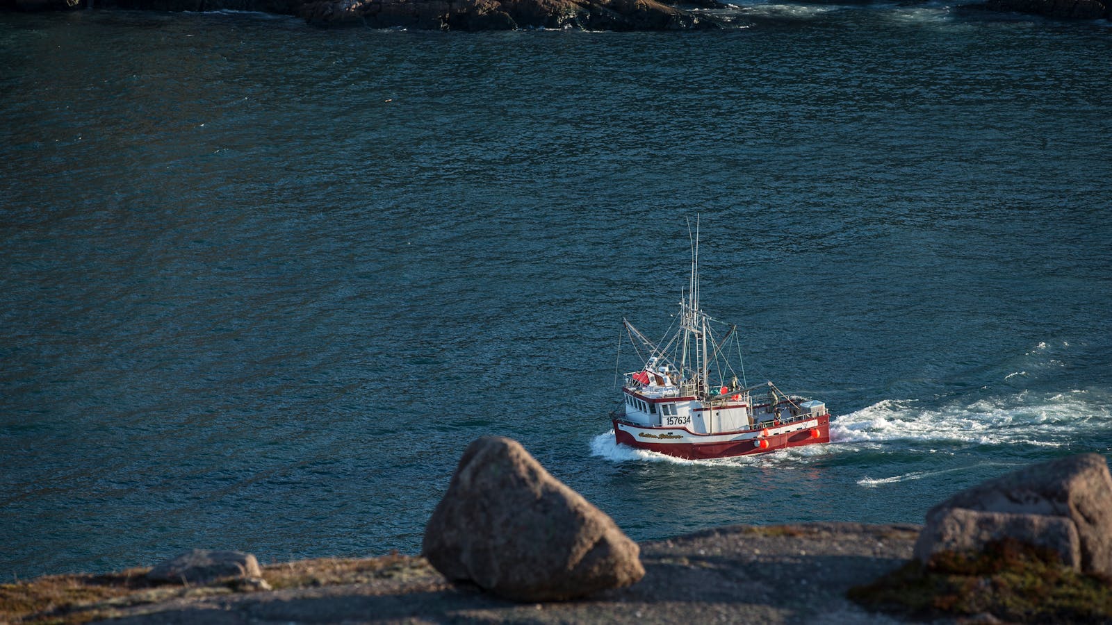 Boat Moving on Water Near Rock