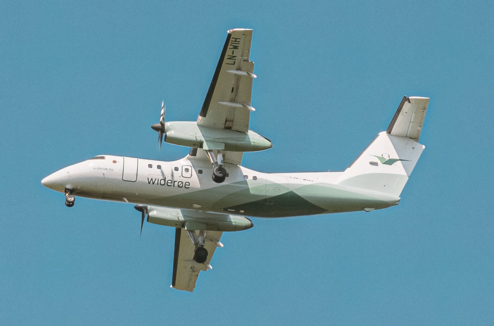 a large air plane flying through a blue sky