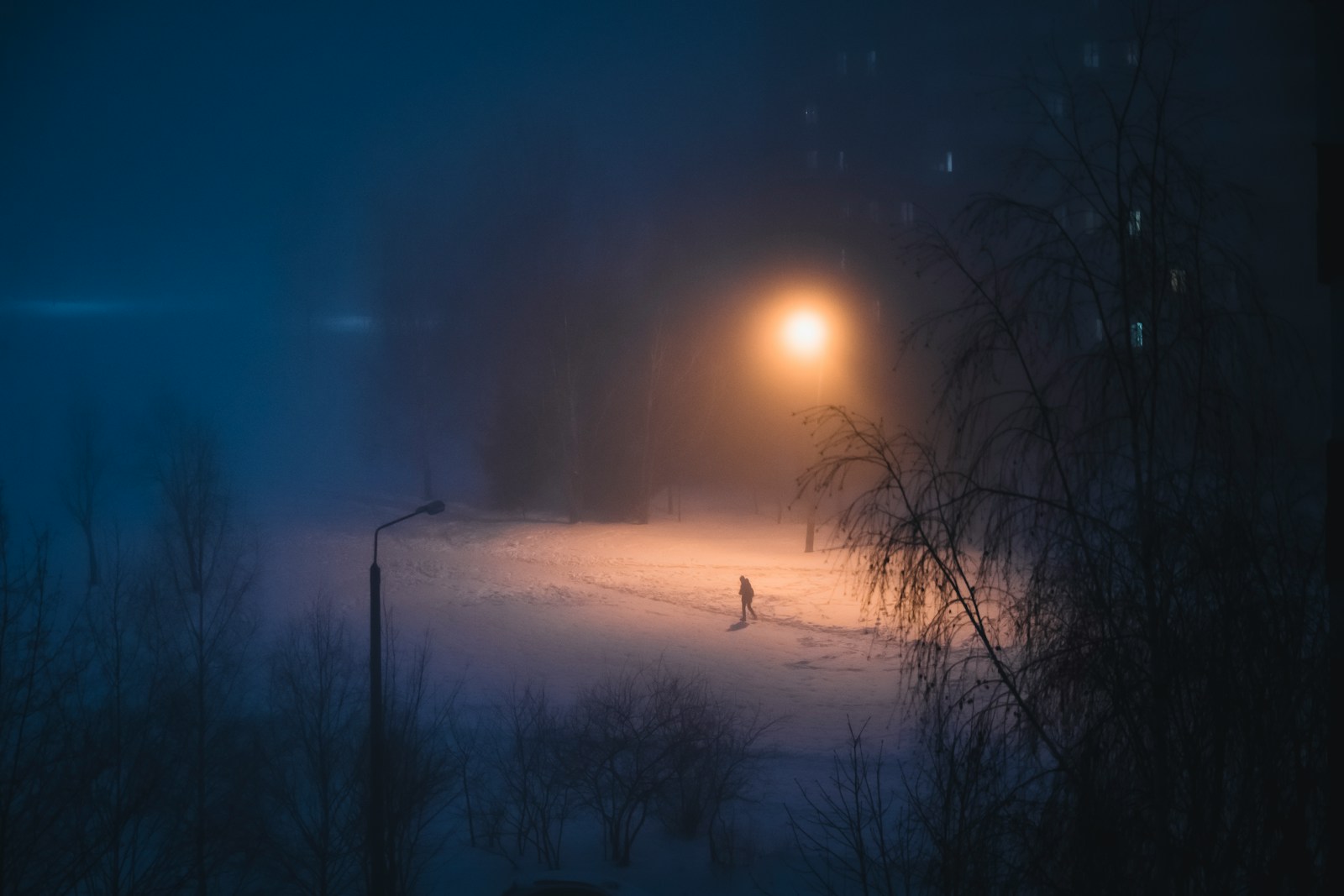 a person walking in the snow at night