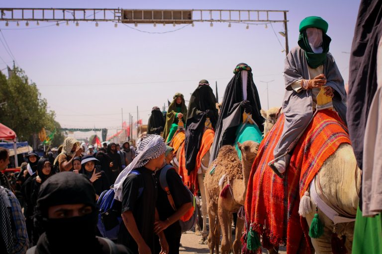 A group of people riding on the backs of camels