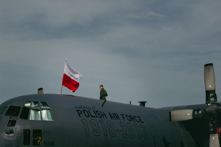 En mann står på toppen av et fly i Polen