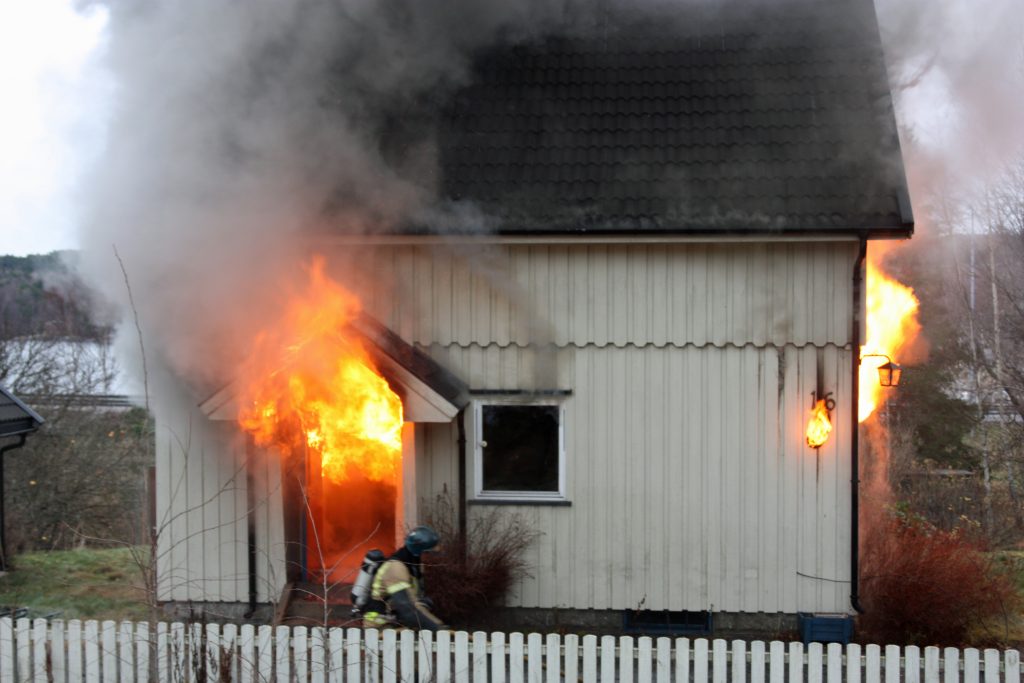 Hus i flammer og brenner