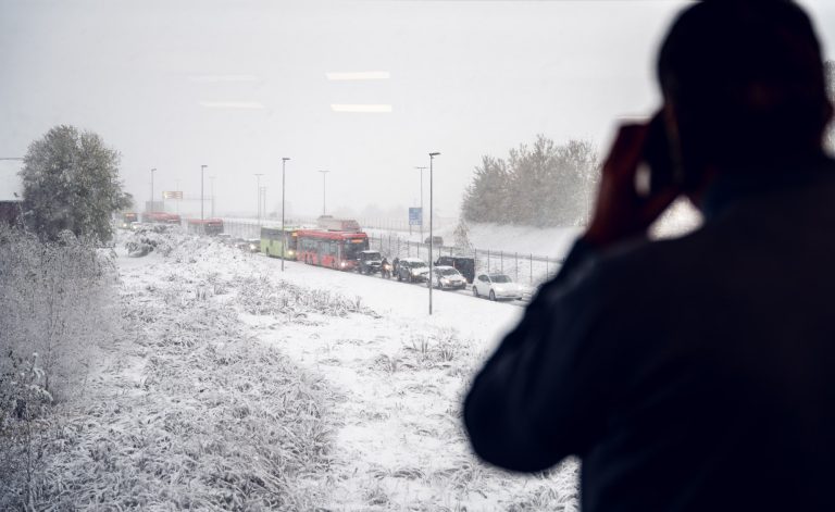 Masse snø og en mann ser på kaoset