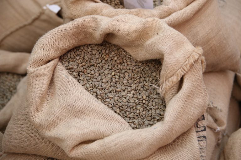 Brune kaffebønner i en tekstil pose