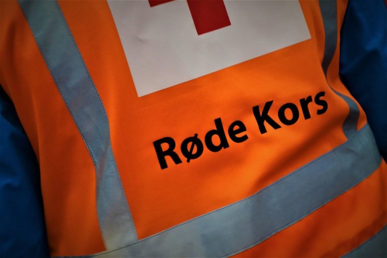 En refleksvest som står Røde Kors