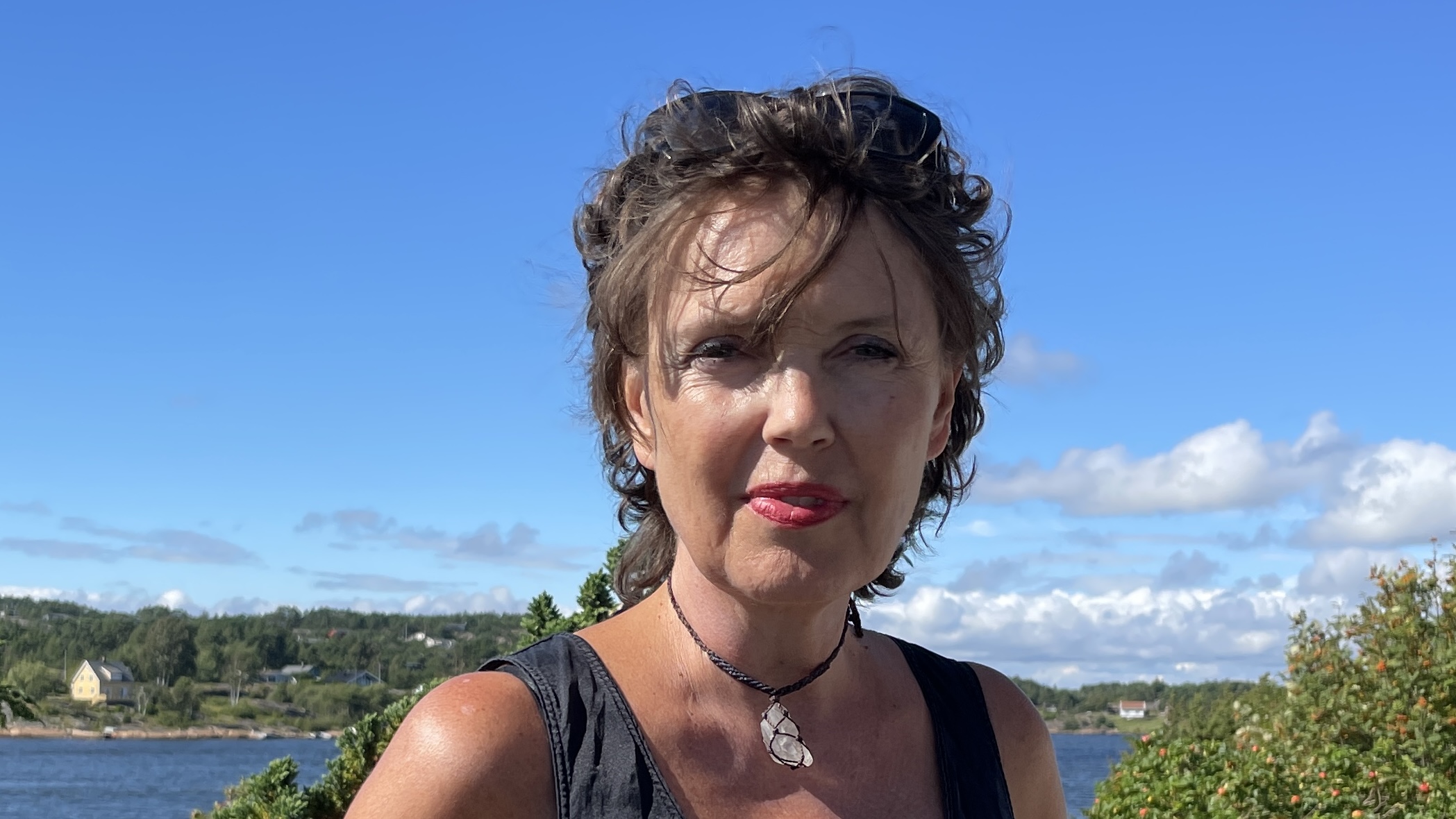 En dame med blå himmel i bakgrunn