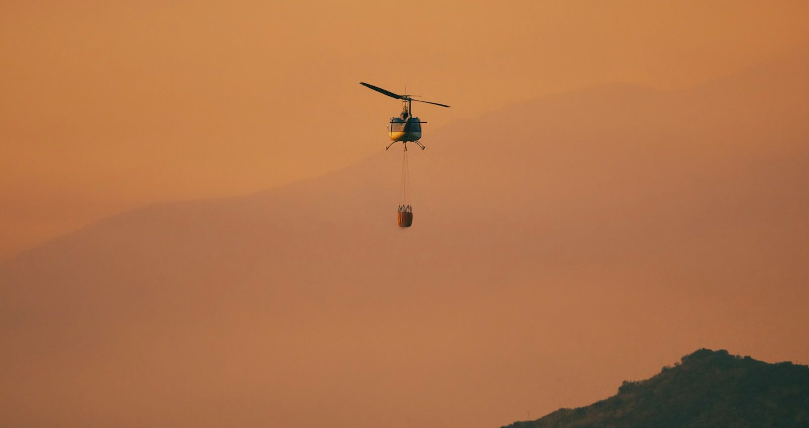 En helikopter flyr over fjellet