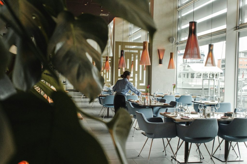 En kvinne står ved et restaurant og jobber