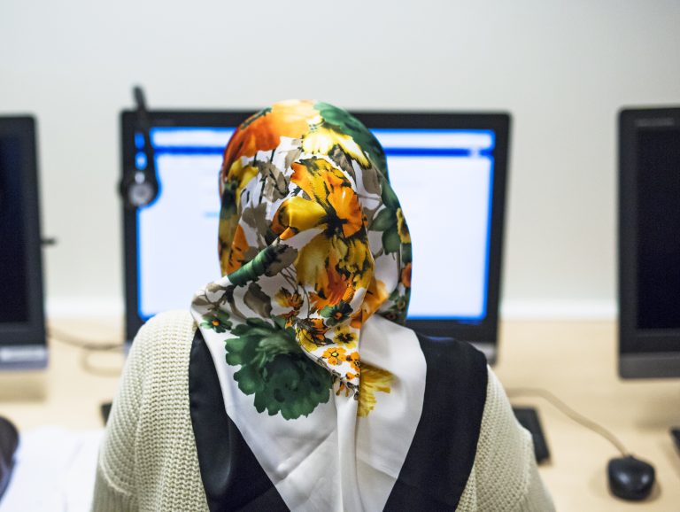 En kvinne som sitter med data