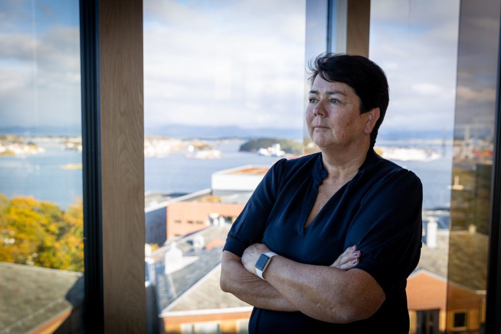 En kvinne som står og ser ut av vindu