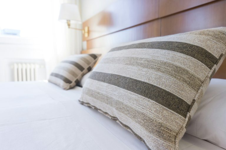 Et hotellrom med senger og puter