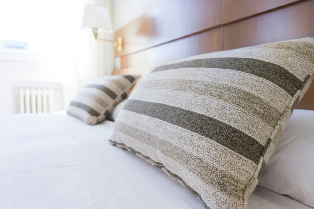Et hotellrom med senger og puter
